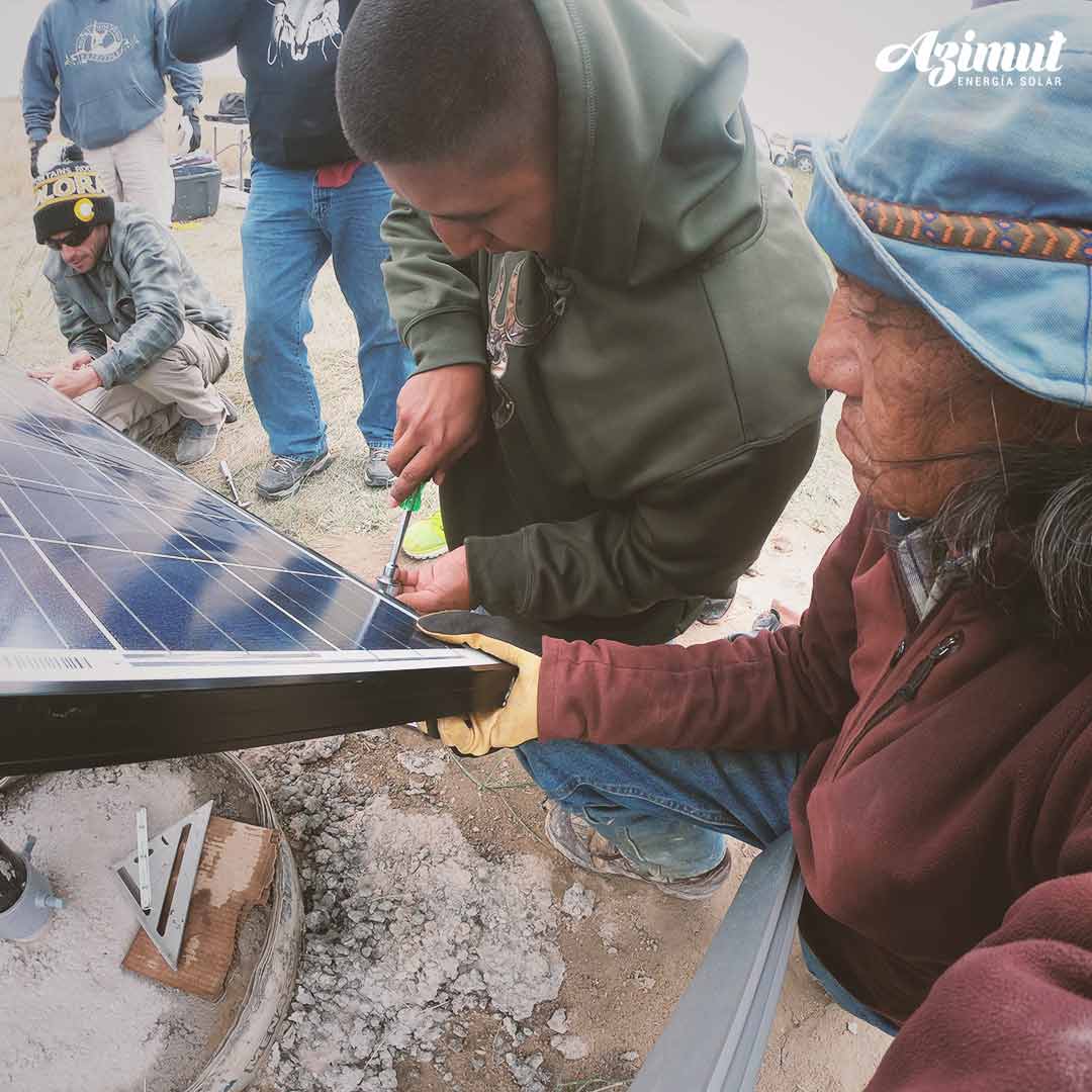 Técnicos y vecinos trabajando juntos en la instalación de un panel solar